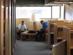 Two people studying in the library
