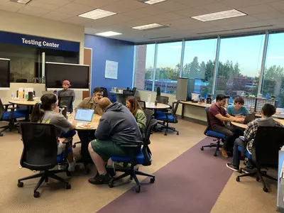 Eight students working on homework in the Portland-Metro Tutoring Center. 