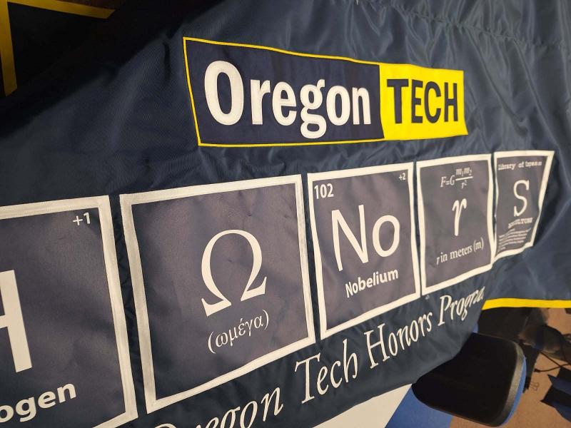 Oregon Tech Honors Program banner featuring the Oregon Tech logo and a row of academic-themed panels with Greek symbols, a Nobelium element symbol, the equation for wavelength, and a large sigma symbol.