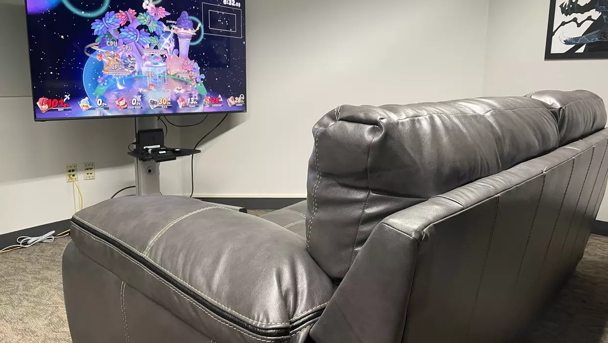 Couch in front of a tv with a nintendo switch