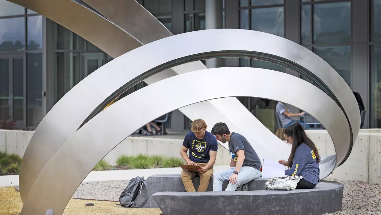 Students sitting at Moment Sculpture