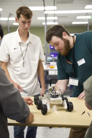 Kanon (left in white shirt) working on robot rover